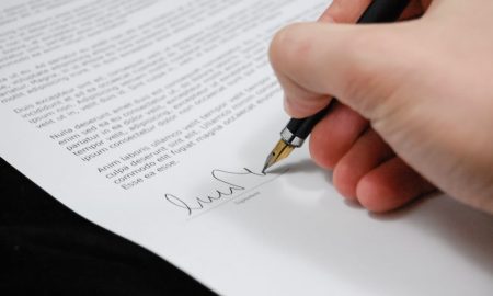 Boat interest rates - Person signing in documentation paper.